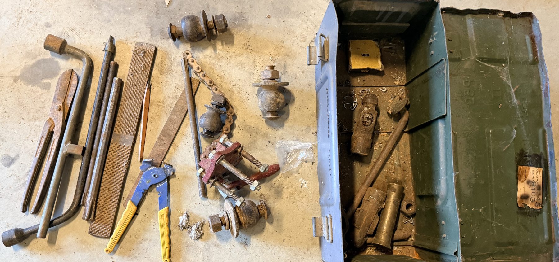 Steel toolbox full of assorted files, snips, punches, and tyre spanners