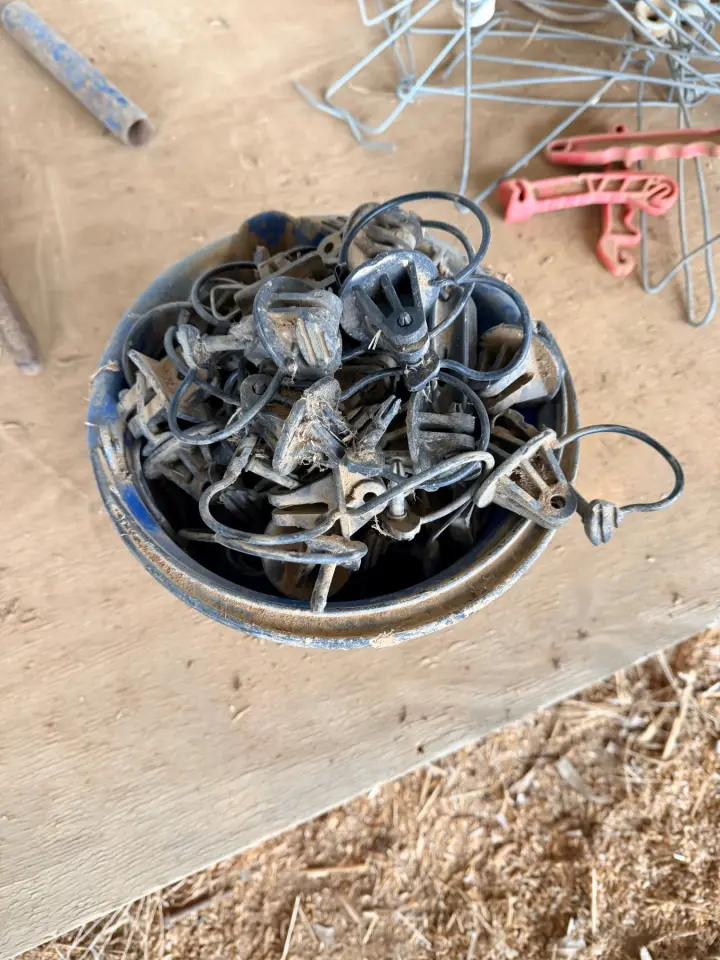 Bucket of electric fence insulators, stand-offs and insulated handles